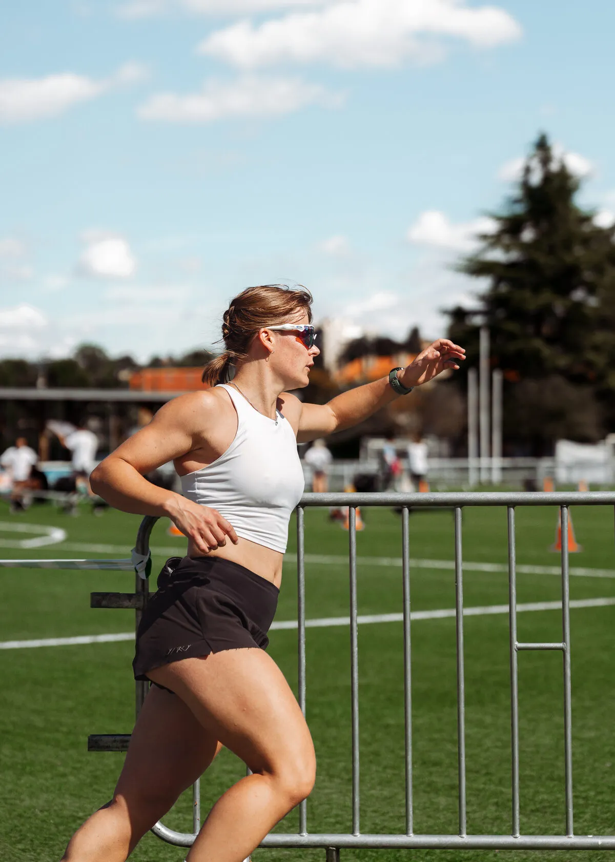 Une athlète en pleine course le long des barrières du parcours